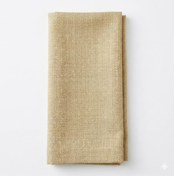 A neatly folded, textured beige Amelia Champagne Linen napkin rests on a plain white background.