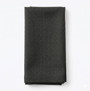 A neatly folded, textured dark gray Amelia Courgette Linen cloth napkin is displayed on a plain white background, perfect for adding an elegant fabric touch to any event setting.