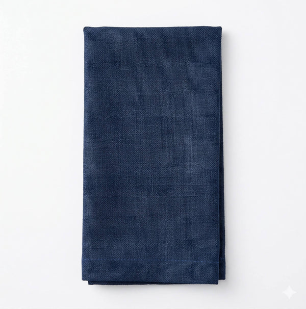 A neatly folded Amelia Dark Blue Linen napkin, made from elegant fabric, lies on a plain white background.