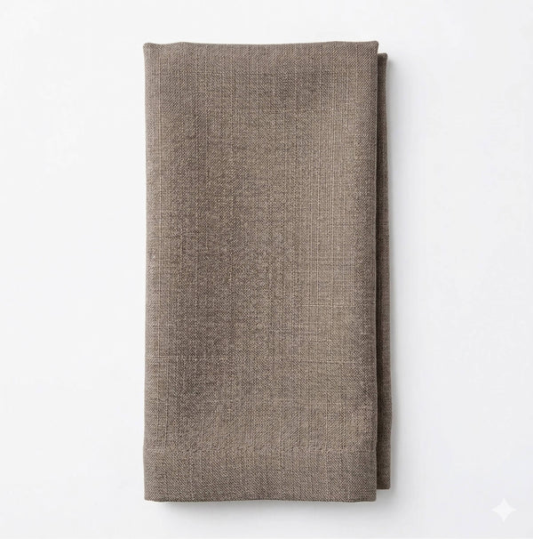 A neatly folded, textured brown Amelia Dark Crème Linen napkin is displayed against a plain white background, ideal for an elegant event setting.