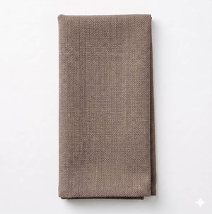 A neatly folded Amelia Dark Taupe Linen napkin, made from elegant linen, is placed on a plain white background.