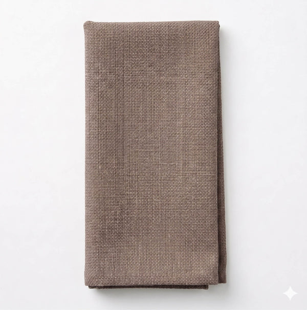 A neatly folded Amelia Dark Taupe Linen napkin, made from elegant linen, is placed on a plain white background.