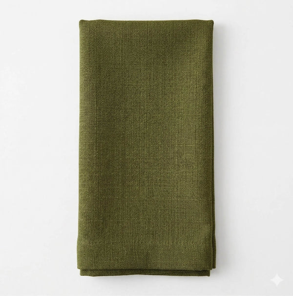 A neatly folded Amelia Grass Green Linen napkin, made of elegant textured fabric, is displayed on a plain white background.