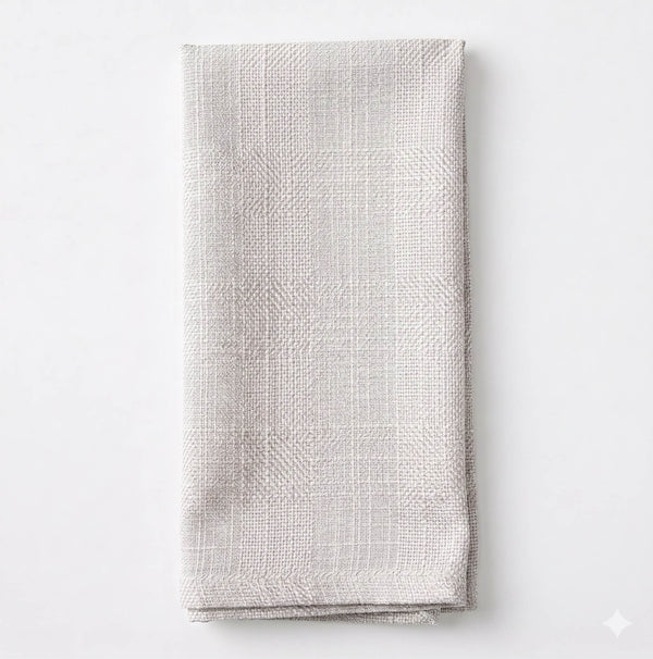 The Amelia Ivory Linen napkin, neatly folded and crafted from elegant textured fabric, is displayed on a plain white background.
