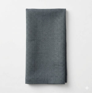 A neatly folded Amelia Jade Green Linen napkin with a subtle herringbone pattern, set against a plain white background—an elegant fabric choice for any event.