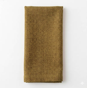 A neatly folded Amelia Light Green Linen napkin, crafted from elegant fabric, is placed on a plain white surface.