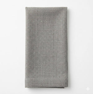 A neatly folded Amelia Light Grey Linen napkin is displayed on a white background, highlighting its elegant texture and versatile style, perfect for any event.