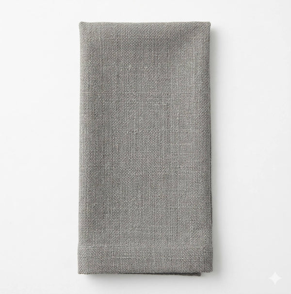 A neatly folded Amelia Light Grey Linen napkin is displayed on a white background, highlighting its elegant texture and versatile style, perfect for any event.