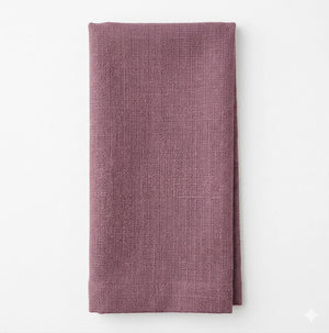 A neatly folded Amelia Mid Purple Linen towel rests on a plain white background, highlighting its elegant texture—perfect for any refined event setting.