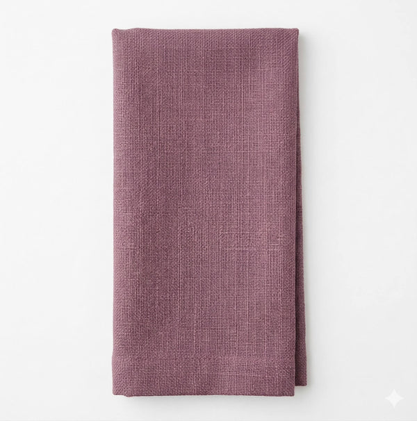 A neatly folded Amelia Mid Purple Linen towel rests on a plain white background, highlighting its elegant texture—perfect for any refined event setting.