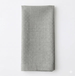 A neatly folded Amelia Pale Blue Linen napkin is displayed on a plain white surface, adding a touch of elegance to any event setting.