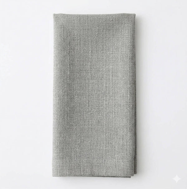A neatly folded Amelia Pale Blue Linen napkin is displayed on a plain white surface, adding a touch of elegance to any event setting.