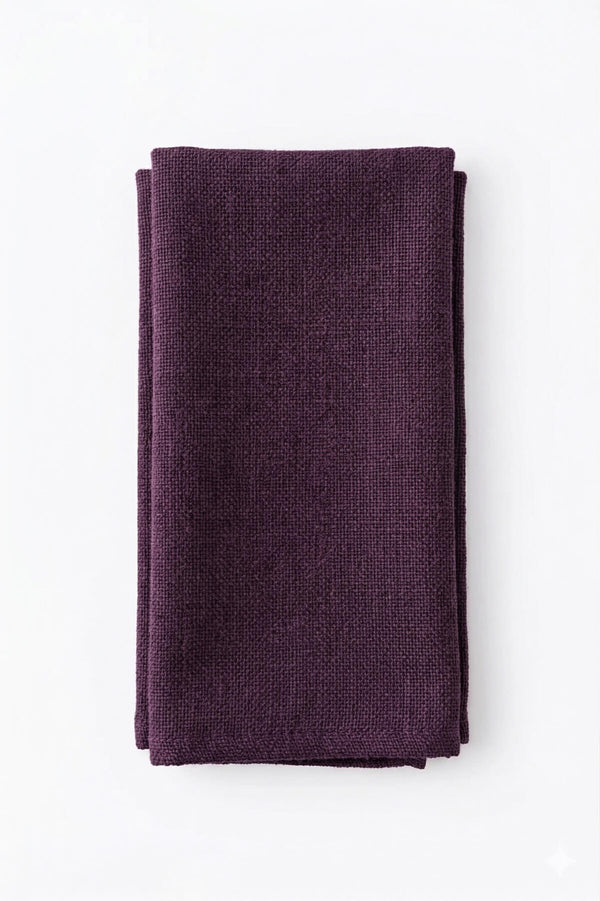 A neatly folded Amelia Purple Linen napkin, featuring a dark purple textured design and elegant fabric, is displayed on a plain white background.