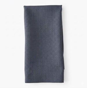 A neatly folded Amelia Steel Blue Linen napkin, crafted from elegant fabric, is displayed against a plain white background.