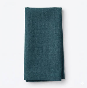 A neatly folded Amelia Turquoise Linen napkin, made from elegant fabric, is displayed against a plain white background.