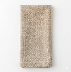 A neatly folded, rectangular Amelia Vanilla Linen napkin made from elegant fabric is placed on a plain white background.