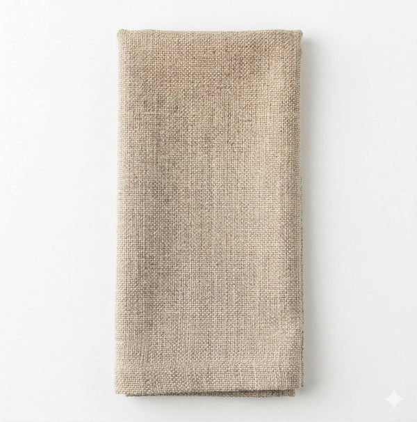 A neatly folded, rectangular Amelia Vanilla Linen napkin made from elegant fabric is placed on a plain white background.
