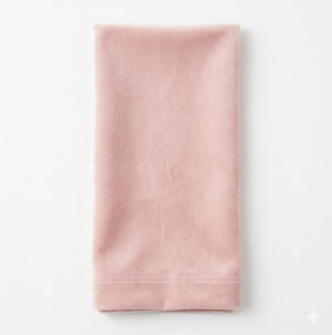The Charlotte Blush Velvet napkin, neatly folded on a white background, showcases its soft pink velvet texture and finished stitching—perfect for elegant event decor.