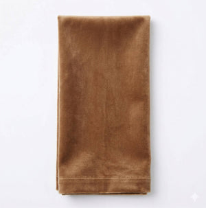 The Charlotte Brown Velvet napkin, neatly folded on a white background, showcases its luxurious fabric—perfect for elevating any event's decor.