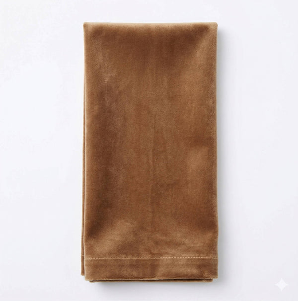 The Charlotte Brown Velvet napkin, neatly folded on a white background, showcases its luxurious fabric—perfect for elevating any event's decor.