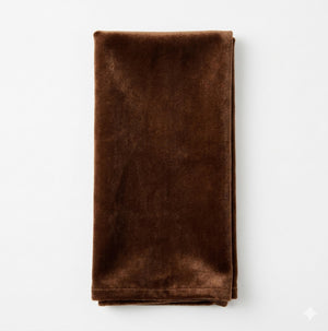 The Charlotte Chocolate Velvet napkin, neatly folded and displayed on a white background, is ideal for adding elegance to any luxurious event decor.