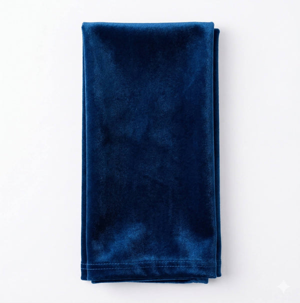 Charlotte Dark Blue Velvet, a neatly folded rich blue luxurious fabric, rests on a white background—perfect for adding sophistication and elegance to any event decor.