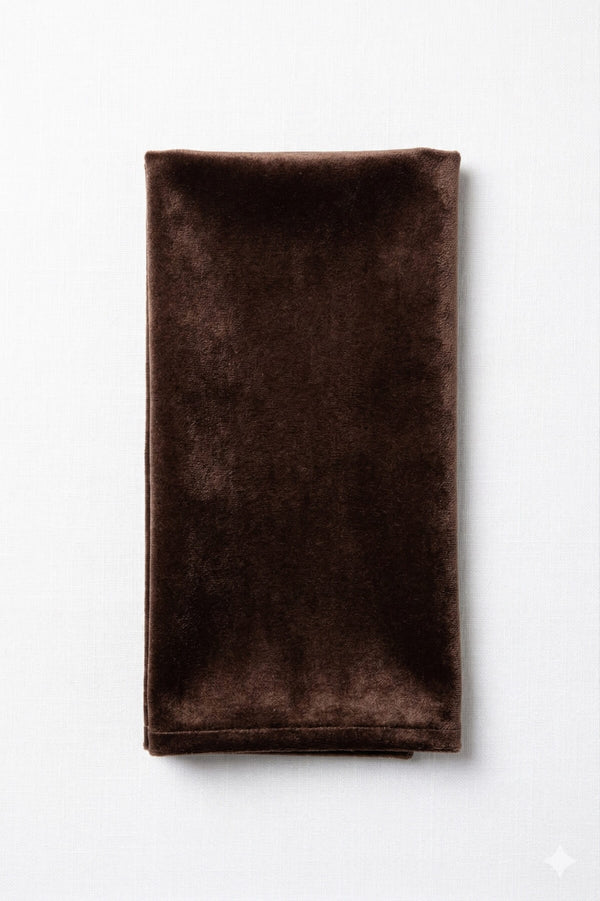 A Charlotte Dark Brown Velvet napkin, neatly folded, is displayed on a white background.