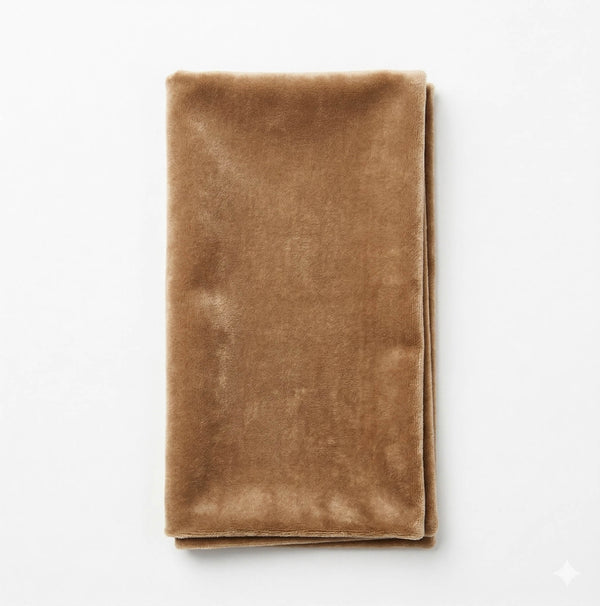 A neatly folded Charlotte Ivory Velvet napkin sits on a plain white background, highlighting its luxurious fabric and elegant appeal, ideal for sophisticated settings.