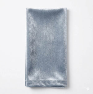 A neatly folded, rectangular Charlotte Light Blue Velvet napkin is displayed on a plain white background, emphasizing its elegant velvet fabric.