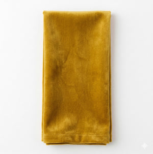 A Charlotte Mustard Velvet napkin, neatly folded, is displayed on a white background.