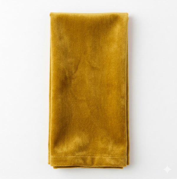 A Charlotte Mustard Velvet napkin, neatly folded, is displayed on a white background.