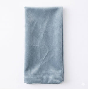 The Charlotte Steel Blue Velvet napkin, elegantly crafted and neatly folded, is displayed on a white background.