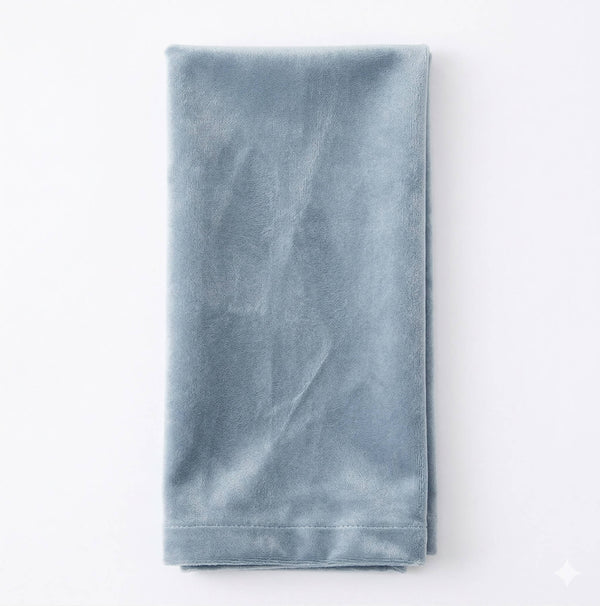 The Charlotte Steel Blue Velvet napkin, elegantly crafted and neatly folded, is displayed on a white background.