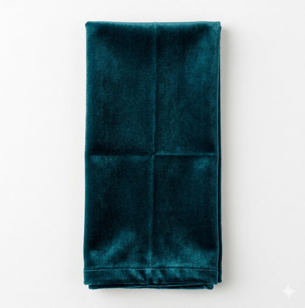 A neatly folded, rectangular Charlotte Teal Green Velvet napkin is displayed on a plain white background.