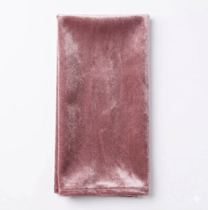 The Charlotte Thistle Velvet napkin, a folded rectangular blush pink linen made from luxurious velvet, rests on a white background—ideal for adding elegance to your event decor.