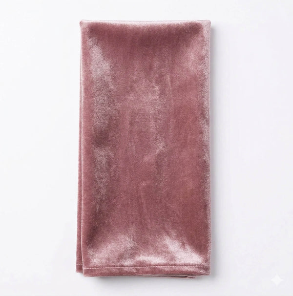 The Charlotte Thistle Velvet napkin, a folded rectangular blush pink linen made from luxurious velvet, rests on a white background—ideal for adding elegance to your event decor.