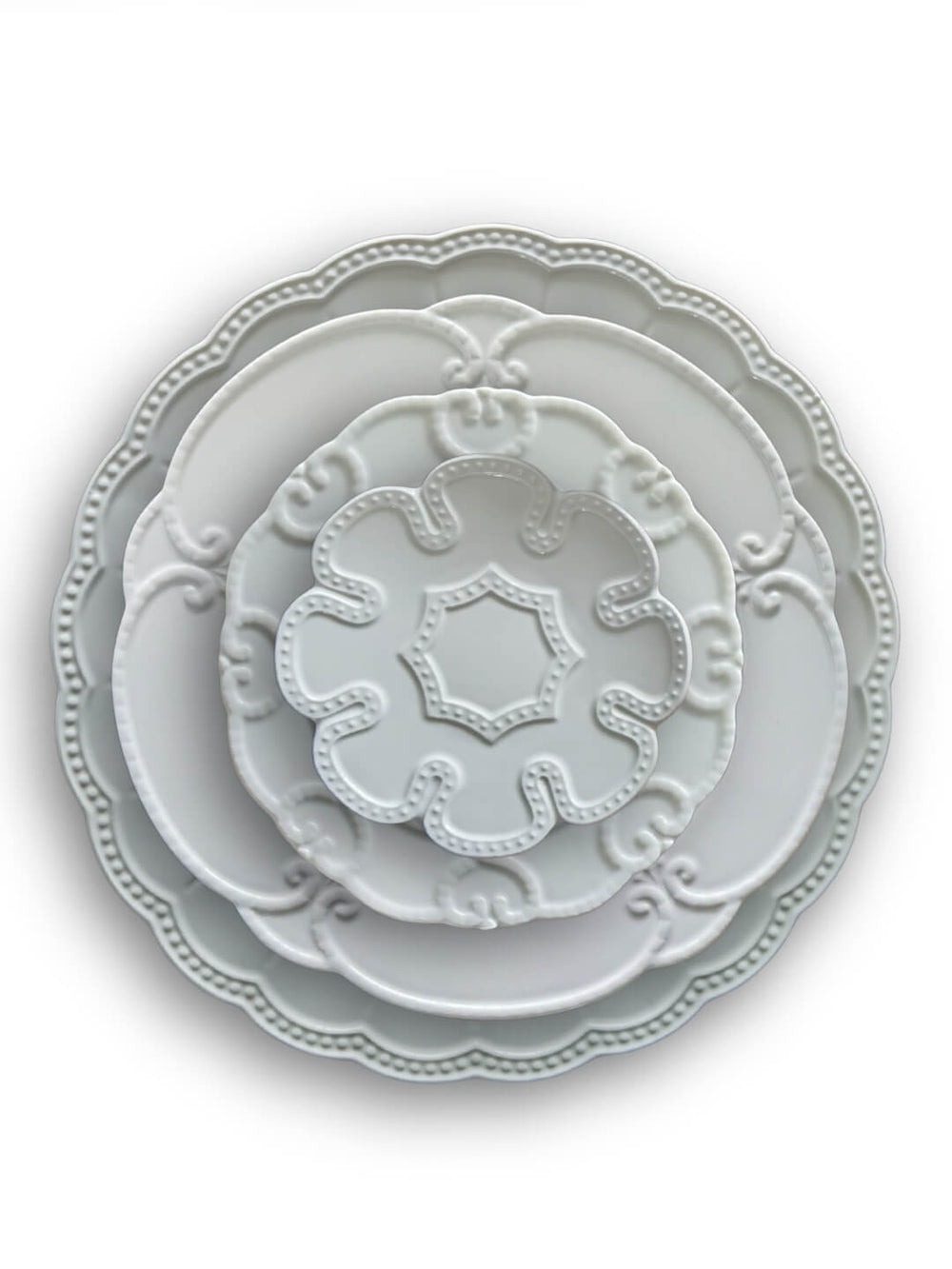 Three Annalise White Plate Range plates in different sizes, each with vintage-inspired decorative edges and embossed patterns, are stacked together and photographed against a plain white background.