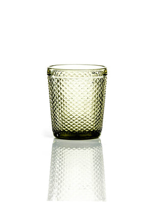 The Apiary Olive Tumbler features a textured, transparent finish with a diamond pattern and sits on a white surface, its reflection visible—perfect as honeycomb glass for rustic wedding decor.