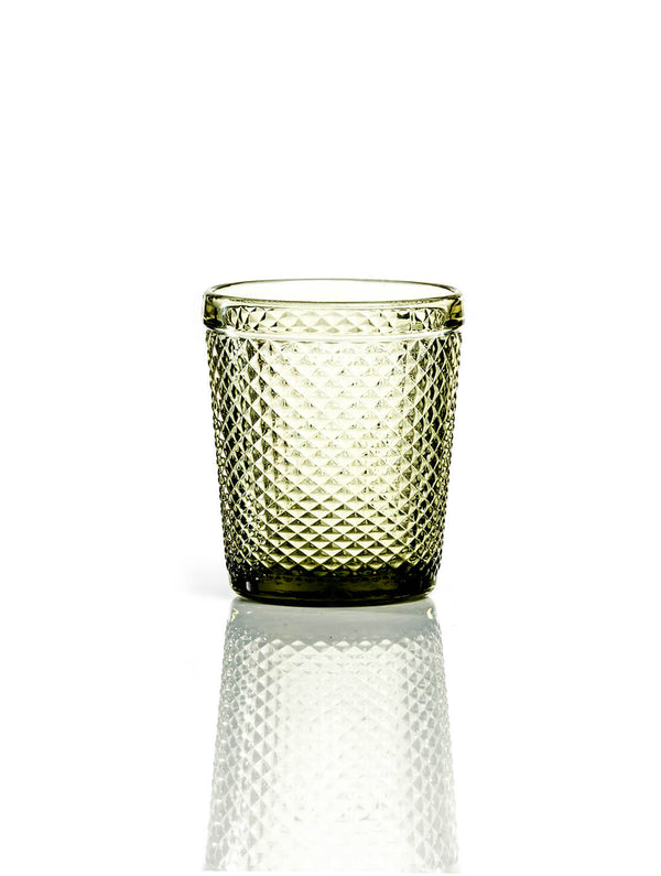 The Apiary Olive Tumbler features a textured, transparent finish with a diamond pattern and sits on a white surface, its reflection visible—perfect as honeycomb glass for rustic wedding decor.