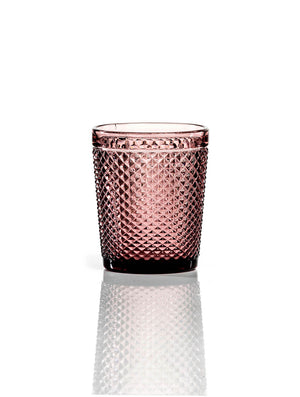 The Apiary Plum Tumbler is a short, round glass with pink-tinted honeycomb texture, adding luxurious style to your drinkware, shown on a reflective white background.