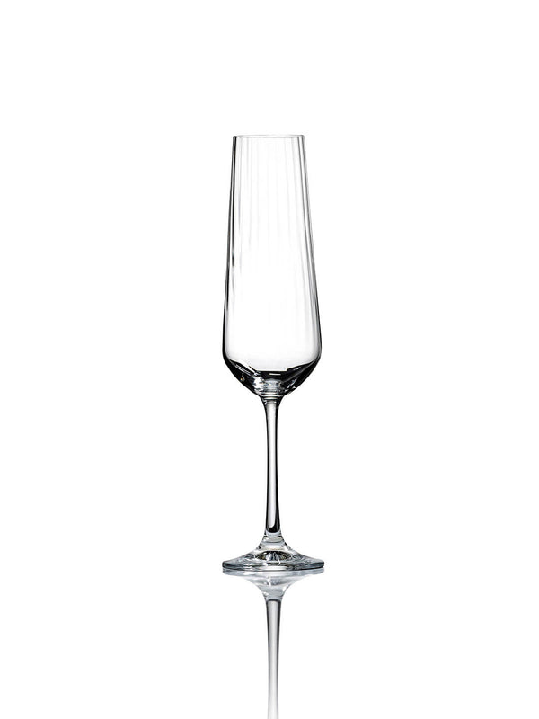 A clear champagne flute from the Catherine Glassware Range, with a subtle ripple pattern and elegant long stem, is centered on a white background, casting a faint reflection—ideal for luxury weddings.