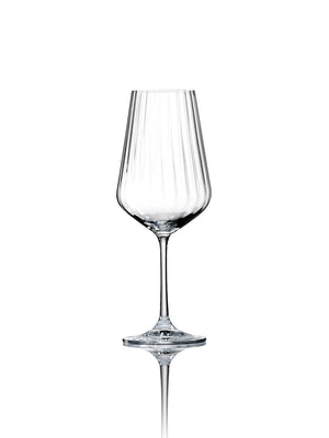 A clear wine glass from the Catherine Glassware Range stands upright on a reflective white surface, featuring a long stem and subtle ripple pattern—ideal for luxury weddings.