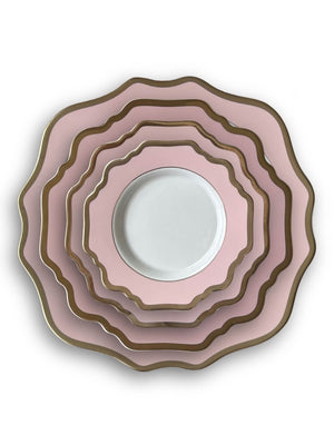 Five Colette Pink plates in graduating sizes, stacked neatly. Each luxury plate has pink and gold trim, except the smallest, which features a white center with a pink and gold scalloped rim. All are viewed from above.