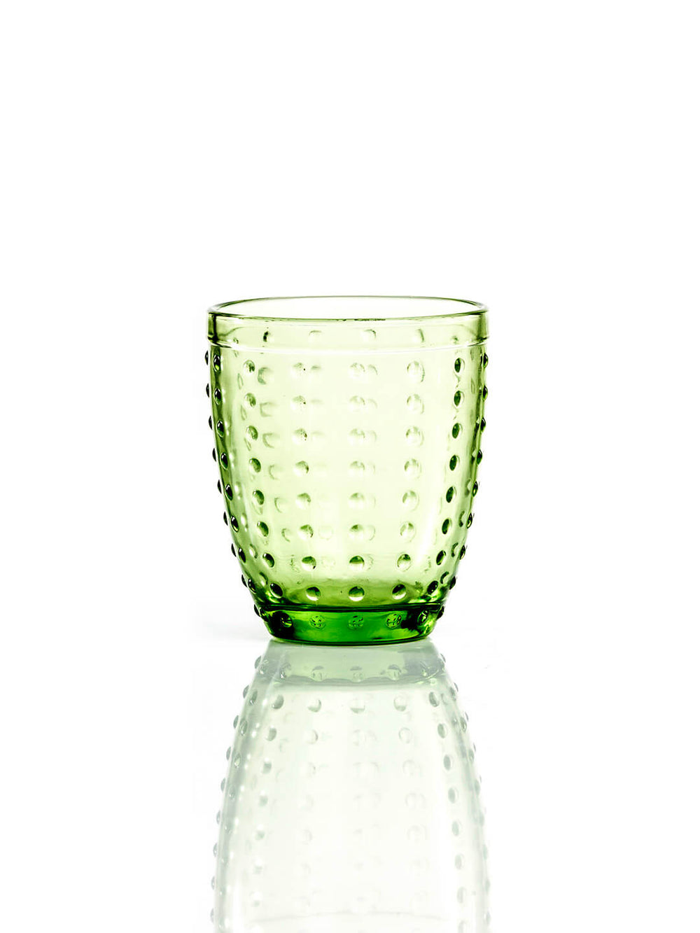 The Dotty Green Tumbler, featuring a textured raised dot design, sits on a reflective white surface—ideal for bringing charm to your garden party or rustic wedding.