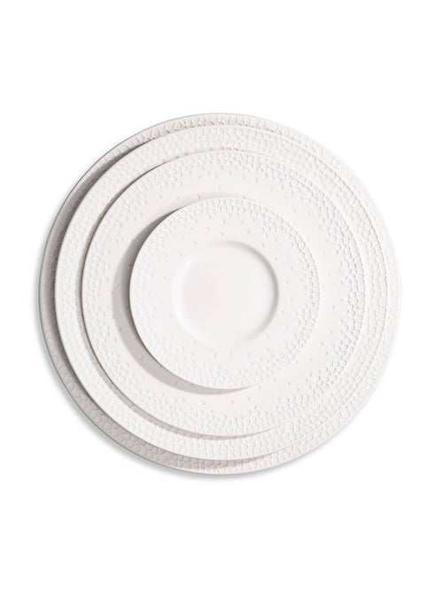 Three stacked white plates from the Dotty Plate Range show an embossed dot pattern on their rims, viewed from above on a white background—ideal modern tableware for those who appreciate subtle texture.
