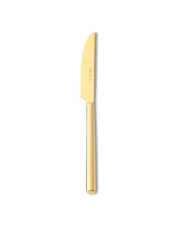 A gold-toned dinner knife from the Gaia Gold Cutlery Range features a smooth, gently curved blade and straight handle, shown vertically on a white background‚Äîideal for elevating your luxury table setting.