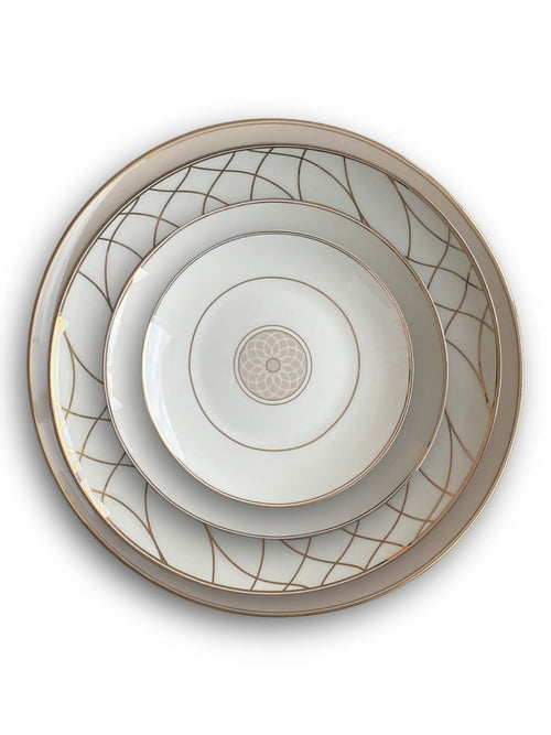 The Grace Plate Range features three nested white ceramic plates with gold rims and geometric patterns; the two larger plates have curved gold lines, while the smallest plate highlights a central gold floral design.