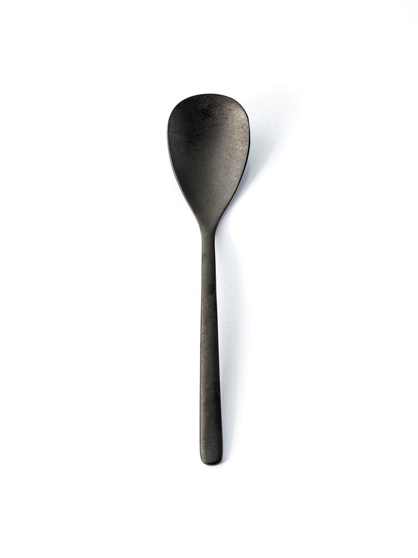 A sleek black metal spoon from the Jett Cutlery Range, featuring a long handle and oval bowl, stands vertically against a white background‚Äîan elegant addition to any modern tableware collection.