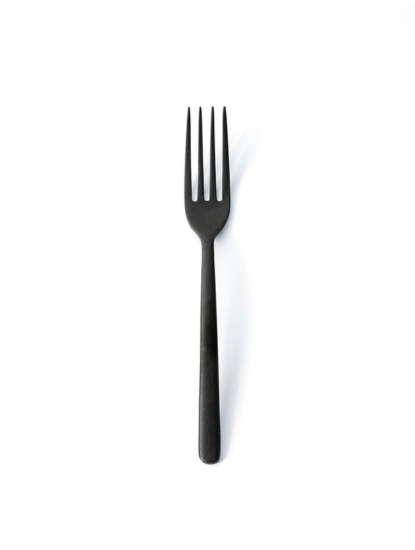 A matte black fork from the Jett Cutlery Range, featuring four tines, is centered on a plain white background, highlighting the sleek appeal of contemporary tableware.