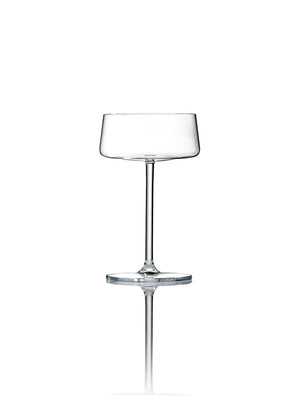 A clear, empty coupe glass from the Lola Glassware Range stands upright on a white background, featuring a wide bowl, slender stem, and subtle reflection for a contemporary look.